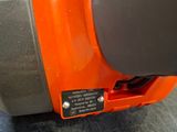 an orange and black vacuum cleaner sitting on top of a blue carpet