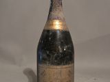 an old bottle of champagne sitting on top of a white table