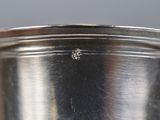 an antique silver plate with a small diamond on the top of it