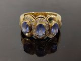 gros plan d'une bague en or avec saphirs bleus et diamants