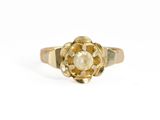 Gros plan sur une bague en or ornée d'une fleur