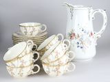 a lot of cups and saucers sitting on a table