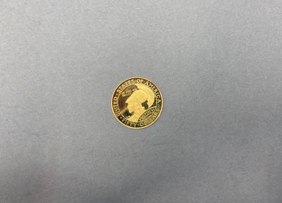 Gros plan sur une pièce d'or ornée d'un oiseau
