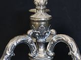 a silver vase on a table with a black background