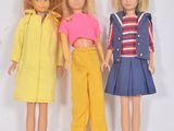 trois poupées de couleurs différentes sont debout les unes à côté des autres