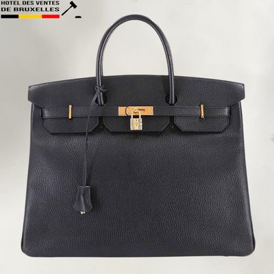 un sac à main en cuir noir orné d'un fermoir doré