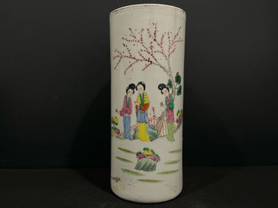 un vase blanc avec un tableau posé sur une table