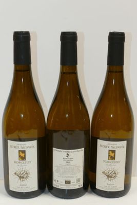 trois bouteilles de vin posées sur une table, l'une à côté de l'autre