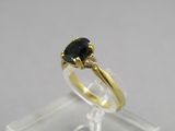gros plan d'une bague en or avec un diamant noir
