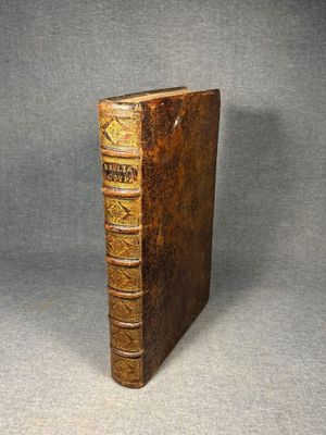 an old book sitting on top of a table next to a gray background