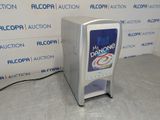 a soda dispenser sitting on the floor in front of a wall
