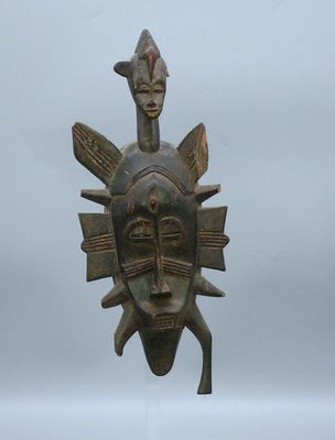 sculpture représentant un masque surmonté d'un oiseau