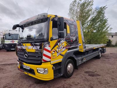 un camion jaune garé sur la terre battue