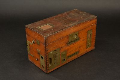 a small wooden box with a metal latch on it
