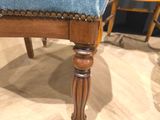 a blue upholstered chair on a wood floor