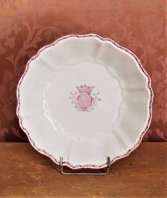 une assiette blanche ornée d'un motif rose, posée sur une table