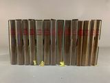 six books are lined up in a row on a white surface