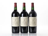 trois bouteilles de vin rouge posées l'une à côté de l'autre sur une surface blanche