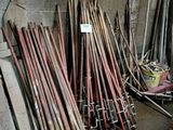 un tas de battes de baseball posées par terre près d'un mur