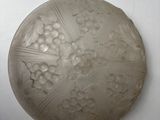 a white plate with a design on it on the wall