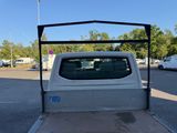 a white truck parked in a parking lot with trees in the background