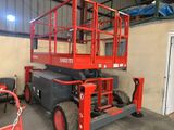 une paire de ciseaux rouges posée dans un garage à côté d'une chaise