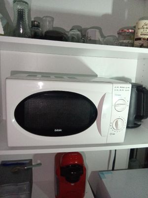 un micro-ondes posé sur une étagère dans une cuisine