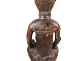 an image of a statue of a person sitting on a stool