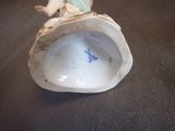 a figurine of a woman sitting on top of a shell