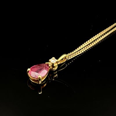 un collier en or orné d'un rubis en forme de cœur sur fond noir