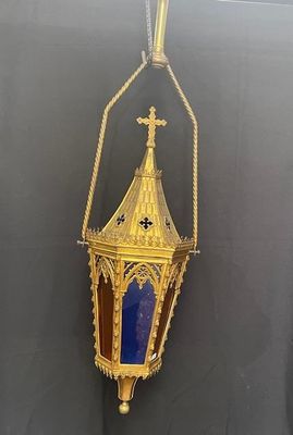 brass and blue glass lantern hanging from a rope