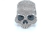 silver skull ring with black and white stones on it