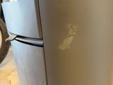 a refrigerator that has a lot of scratches on it