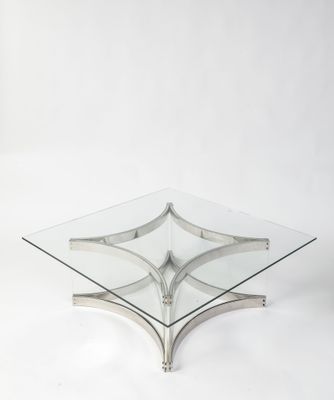 une table basse en verre et chrome avec un plateau carré en verre