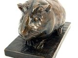 statue of a pig on a wooden base on a white background