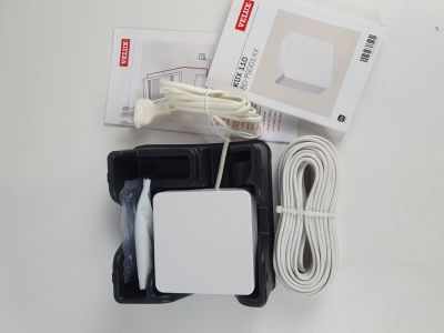 une boîte contenant un câble et un chargeur, posée sur la table