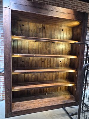une bibliothèque en bois avec une étagère métallique en dessous