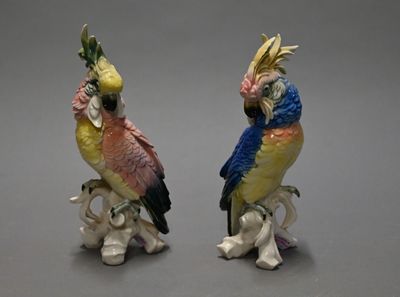 two figurines of parrots sitting on top of each other on a table