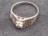 a silver ring with a stone in it on a gray cloth