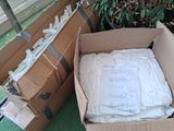 two cardboard boxes with white shirts in them on the ground