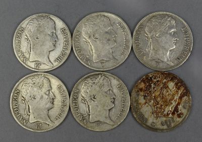 six silver coins of different sizes and shapes on a gray surface