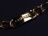 a close up of a gold chain bracelet with the word chanel on it