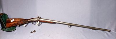 an old rifle with a wooden barrel and a green case