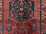 a red and blue rug with an ornate design on it
