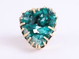 green tourmaline heart shaped ring with gold accents on white background