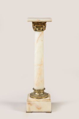 un socle en marbre blanc avec une base dorée et un plateau en marbre