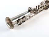 a silver flute that is sitting on a white surface