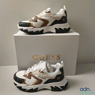 deux paires de baskets blanches et marron posées sur une boîte blanche