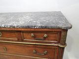 a marble top on a wooden chest of drawers