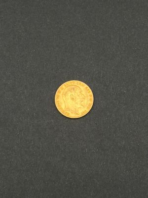 gros plan d'une pièce d'or sur une surface noire